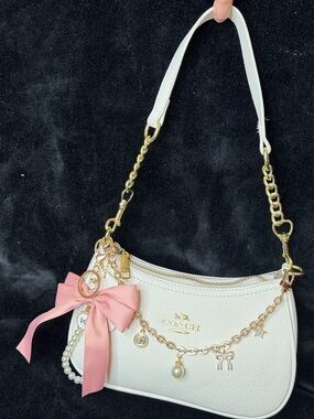 Coach White Pebbled Leather Shoulder Bag with Pink Bow Charm and Gold Accents
